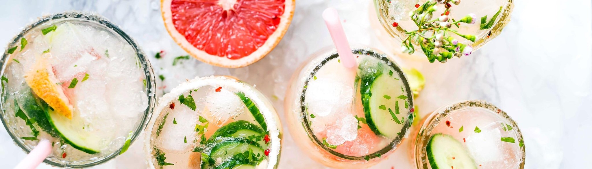 Eisgekühlte Cocktails mit Gurke, Blüten, Gin Tonic und Grapefruit.